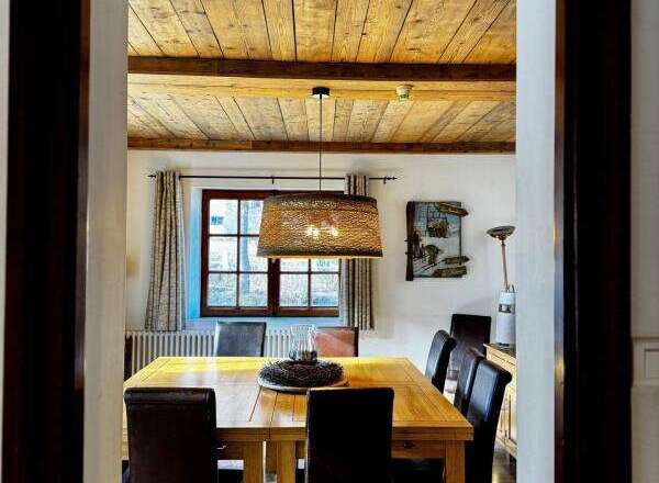 Step into a charming dining room with a rustic wooden ceiling and a warm, inviting atmosphere.