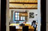 Step into a charming dining room with a rustic wooden ceiling and a warm, inviting atmosphere.