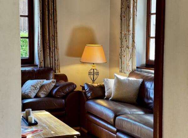 This cozy living room features comfortable leather sofas, perfect for relaxing after a long day.