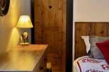 Discover the charm of this cozy bedroom featuring a rustic wooden wardrobe with a heart-shaped detail.
