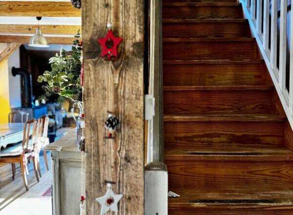 Discover the charm of this property, featuring a beautifully crafted wooden staircase and rustic interior details.