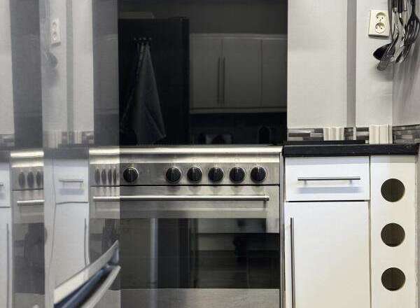 This modern kitchen boasts sleek stainless steel appliances, including a stylish oven and range hood.
