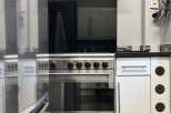 This modern kitchen boasts sleek stainless steel appliances, including a stylish oven and range hood.