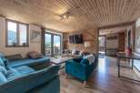 Step into this charming living space, featuring a cozy seating area and a warm wooden ceiling.