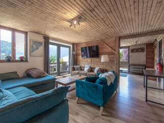 Step into this charming living space, featuring a cozy seating area and a warm wooden ceiling.