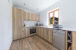 This modern kitchen boasts a sleek design with light wood cabinetry and a bright, airy feel.