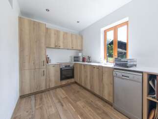 This modern kitchen boasts a sleek design with light wood cabinetry and a bright, airy feel.