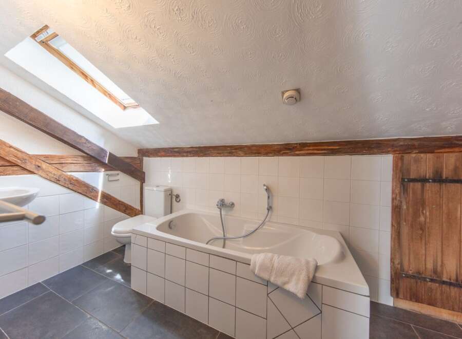 Discover the charm of this unique bathroom, featuring a skylight that bathes the space in natural light.