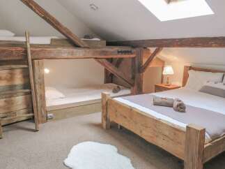 This charming bedroom features a unique design with rustic wooden beams and a cozy atmosphere.