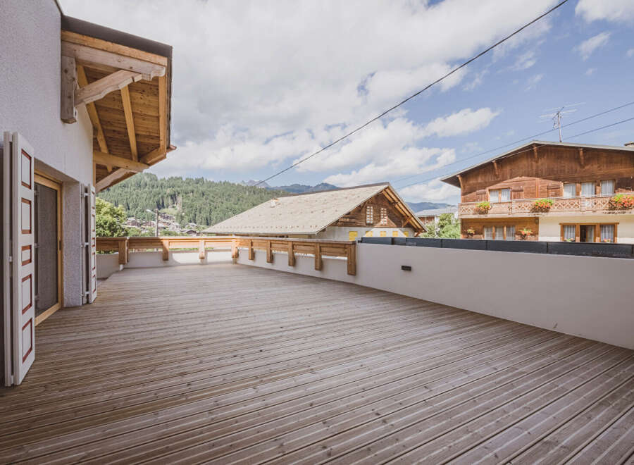 Enjoy breathtaking mountain views from this stunning property with a spacious wooden deck.