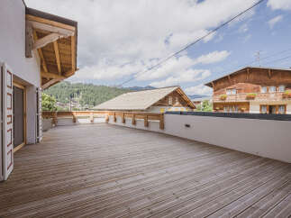 Enjoy breathtaking mountain views from this stunning property with a spacious wooden deck.