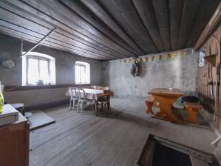 Step back in time with this rustic property! Featuring a charming dining area with a wooden table and benches, perfect for cozy gatherings.