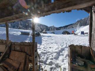 Discover a winter wonderland retreat! This charming property boasts stunning views of snow-covered mountains and a bright blue sky.