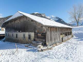 This charming wooden barn, nestled in a snowy landscape, offers a unique opportunity for those seeking a rustic retreat.
