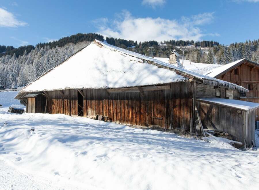 Nestled in a snowy landscape, this charming wooden cabin offers a cozy retreat.