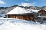 Nestled in a snowy landscape, this charming wooden cabin offers a cozy retreat.