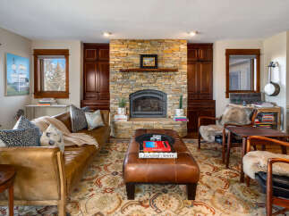 Step into luxury with this stunning living room, featuring a cozy fireplace and elegant leather furniture.