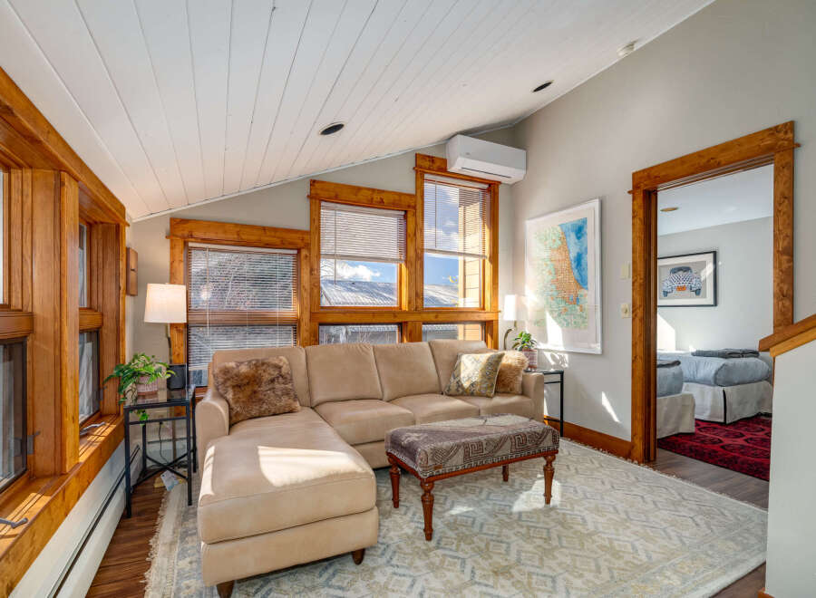 Discover the charm of this inviting living space, featuring a cozy sectional sofa and a stylish ottoman.