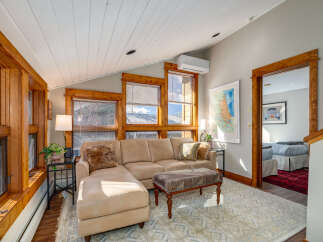 Discover the charm of this inviting living space, featuring a cozy sectional sofa and a stylish ottoman.