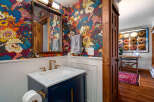 Step into this stylish bathroom featuring a vibrant floral wallpaper that adds a pop of color and personality.