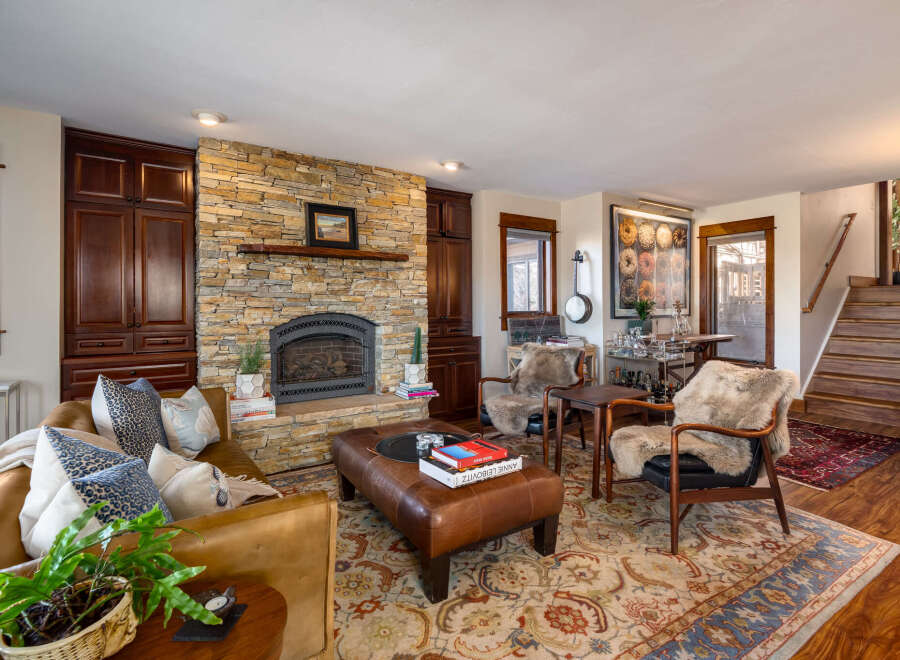 This stunning living room boasts a cozy fireplace with a stone facade, perfect for those chilly evenings.