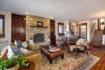 This stunning living room boasts a cozy fireplace with a stone facade, perfect for those chilly evenings.