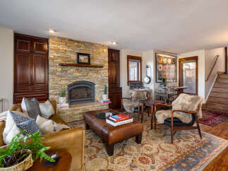 This stunning living room boasts a cozy fireplace with a stone facade, perfect for those chilly evenings.