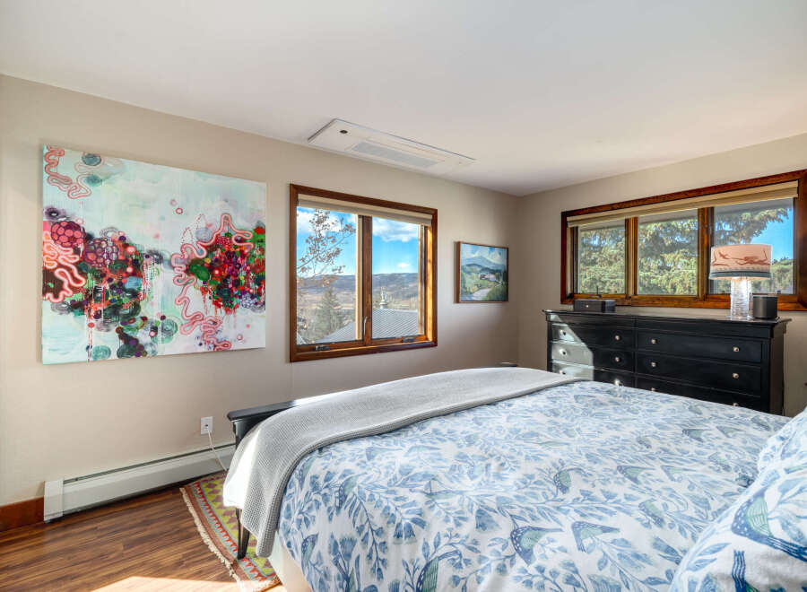 This bedroom offers a serene retreat with its tasteful decor and abundant natural light.