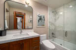Step into a beautifully designed bathroom featuring a modern vanity with a marble countertop and a sleek, framed mirror.