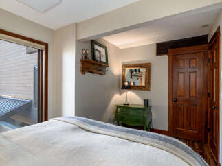 This cozy bedroom features a comfortable bed with a stylish blanket, perfect for a relaxing retreat.