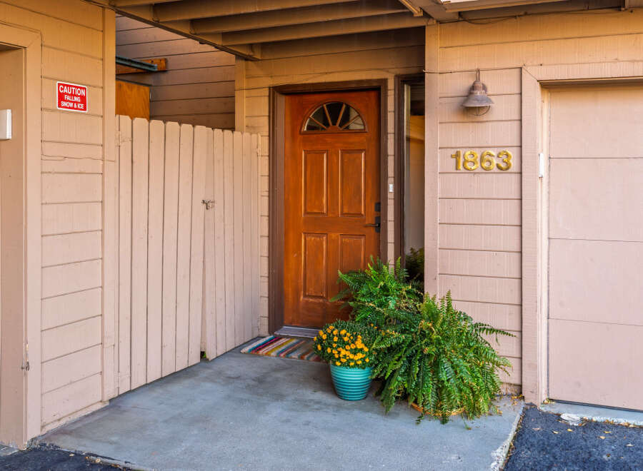 Charming property entrance with a warm, inviting wooden door and a welcoming porch.
