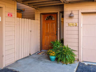 Charming property entrance with a warm, inviting wooden door and a welcoming porch.