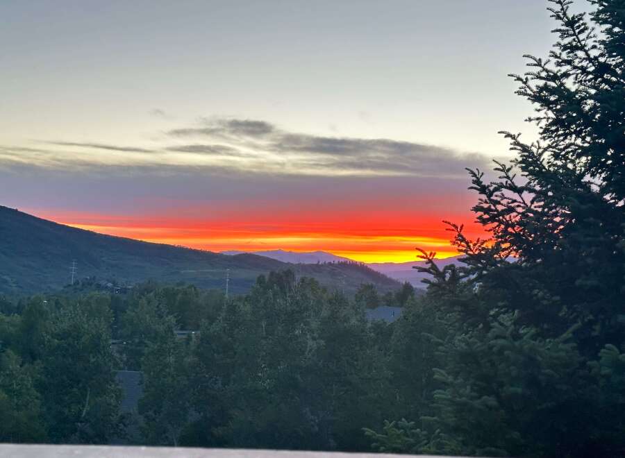 Enjoy breathtaking sunsets from this stunning property! This home offers panoramic views of the mountains and lush greenery.
