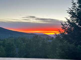 Enjoy breathtaking sunsets from this stunning property! This home offers panoramic views of the mountains and lush greenery.