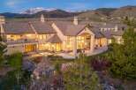 This stunning property boasts a luxurious design with expansive windows offering breathtaking mountain views.