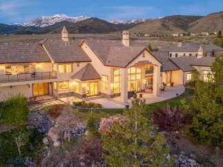 This stunning property boasts a luxurious design with expansive windows offering breathtaking mountain views.