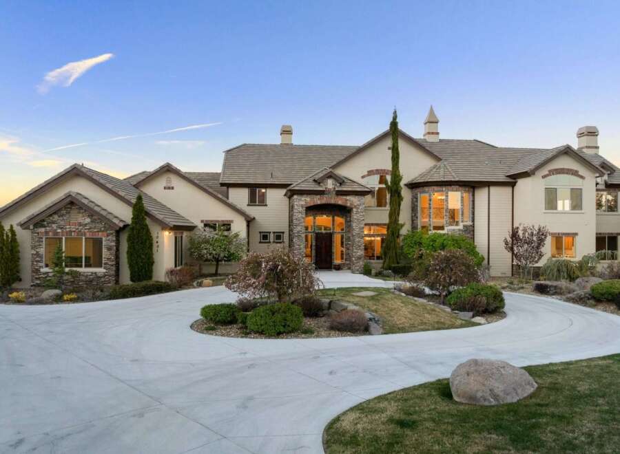 This stunning property boasts a grand entrance with a circular driveway, perfect for welcoming guests.
