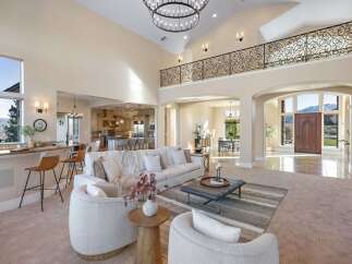 Step into luxury with this stunning property, showcasing a grand entryway and an open-concept living space.