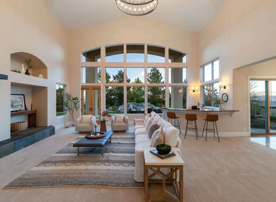 Experience luxury living in this stunning property, featuring a spacious living area with soaring ceilings and expansive windows that flood the space with natural light.
