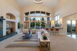 Experience luxury living in this stunning property, featuring a spacious living area with soaring ceilings and expansive windows that flood the space with natural light.