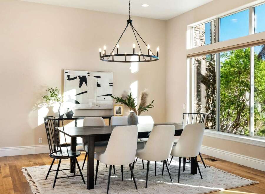 Step into luxury with this stunning dining room, featuring a modern chandelier and a stylish dining table.