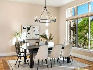 Step into luxury with this stunning dining room, featuring a modern chandelier and a stylish dining table.