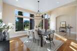 Step into luxury with this stunning dining room, featuring a modern chandelier and a large dining table perfect for hosting.