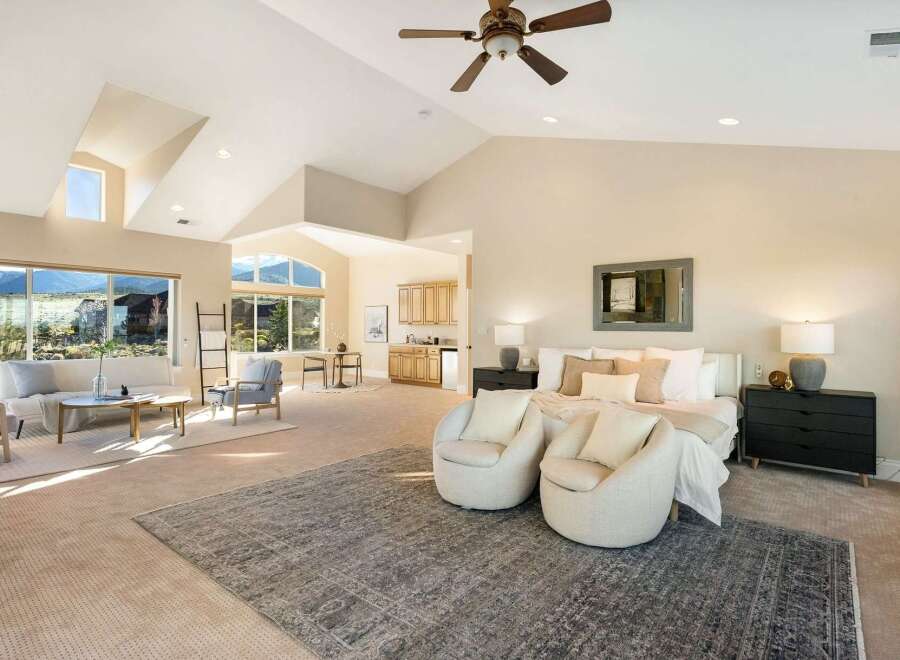Experience luxury living in this stunning property, featuring a spacious master suite with a cozy seating area.
