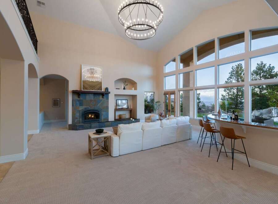 Experience luxury living in this stunning property featuring a grand living room with soaring ceilings and a cozy fireplace.