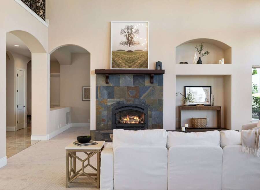 This stunning living room boasts a cozy fireplace with a beautiful stone surround, perfect for those chilly evenings.