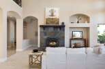 This stunning living room boasts a cozy fireplace with a beautiful stone surround, perfect for those chilly evenings.