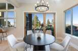 Experience luxury living in this stunning property! This dining area features a modern round table, elegant chairs, and a beautiful chandelier.