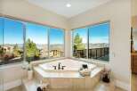 Indulge in luxury with this stunning bathroom featuring a corner jacuzzi tub and breathtaking views.