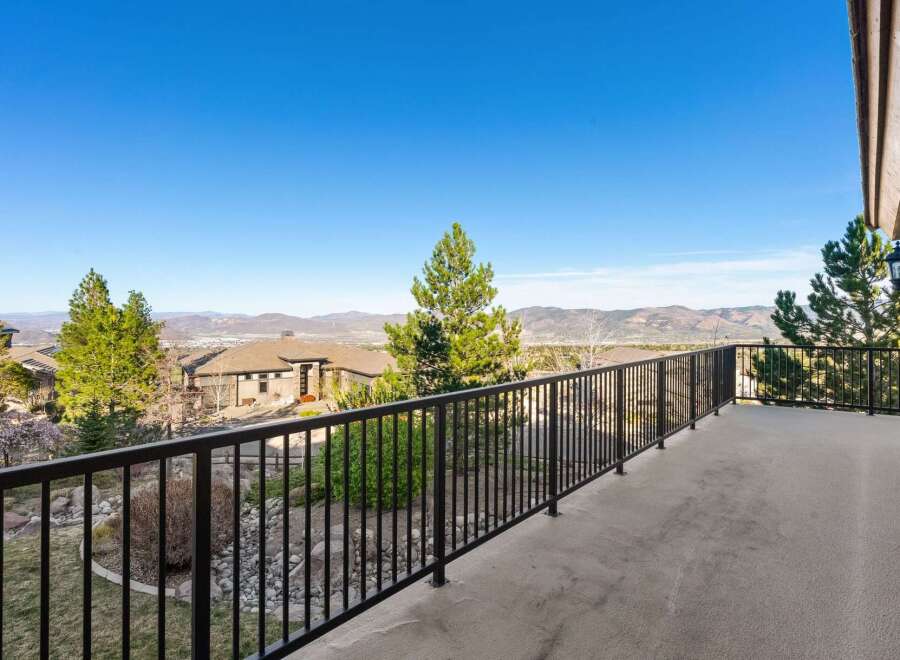 Enjoy breathtaking views from this stunning property! This home features a spacious balcony with a sleek black railing, perfect for relaxing and taking in the scenery.